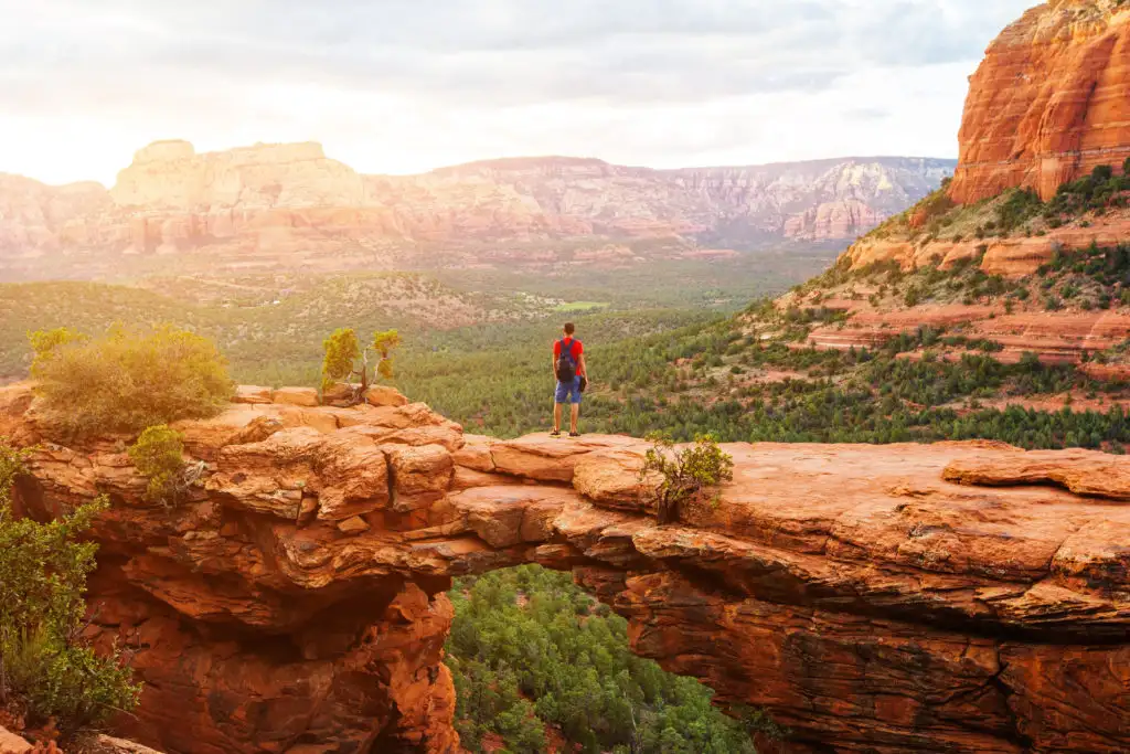 Man standing on top of Devil's Bridge in Sedona, Arizona